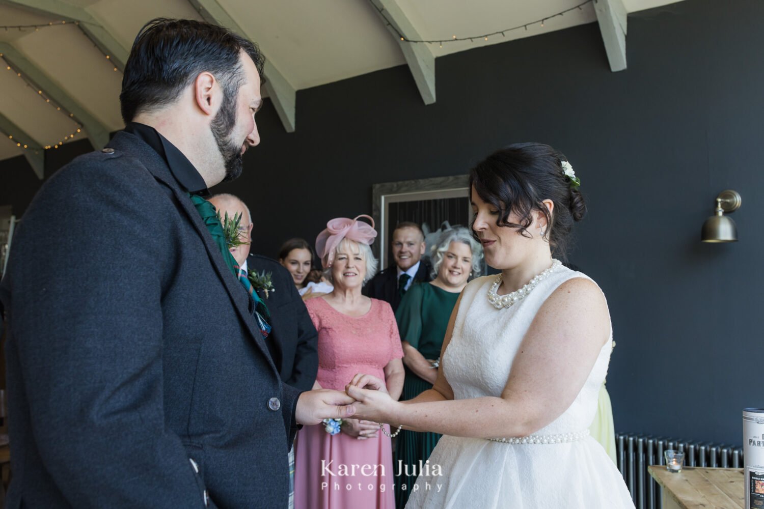 bride and groom exchange rings during their wedding ceremony