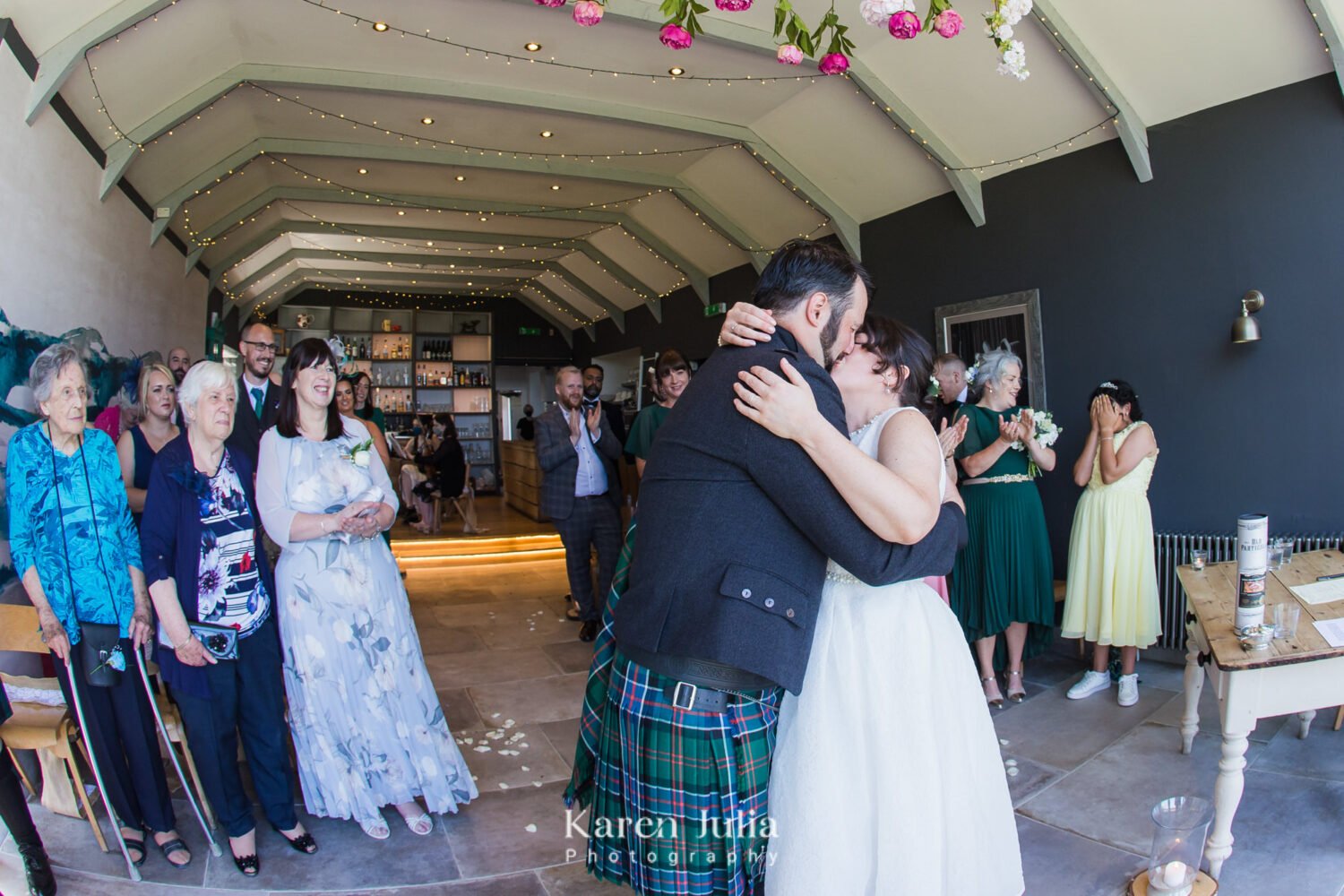 bride and groom kiss each other as they are announced to be officially married