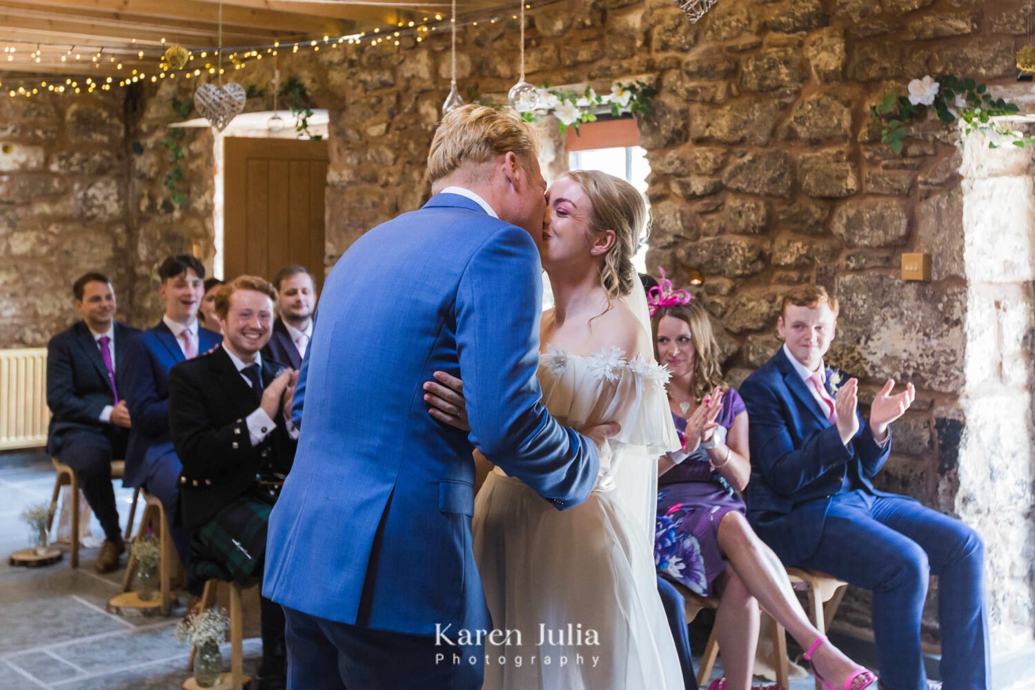 bride and groom kiss as they are announced husband and wife during wedding ceremony