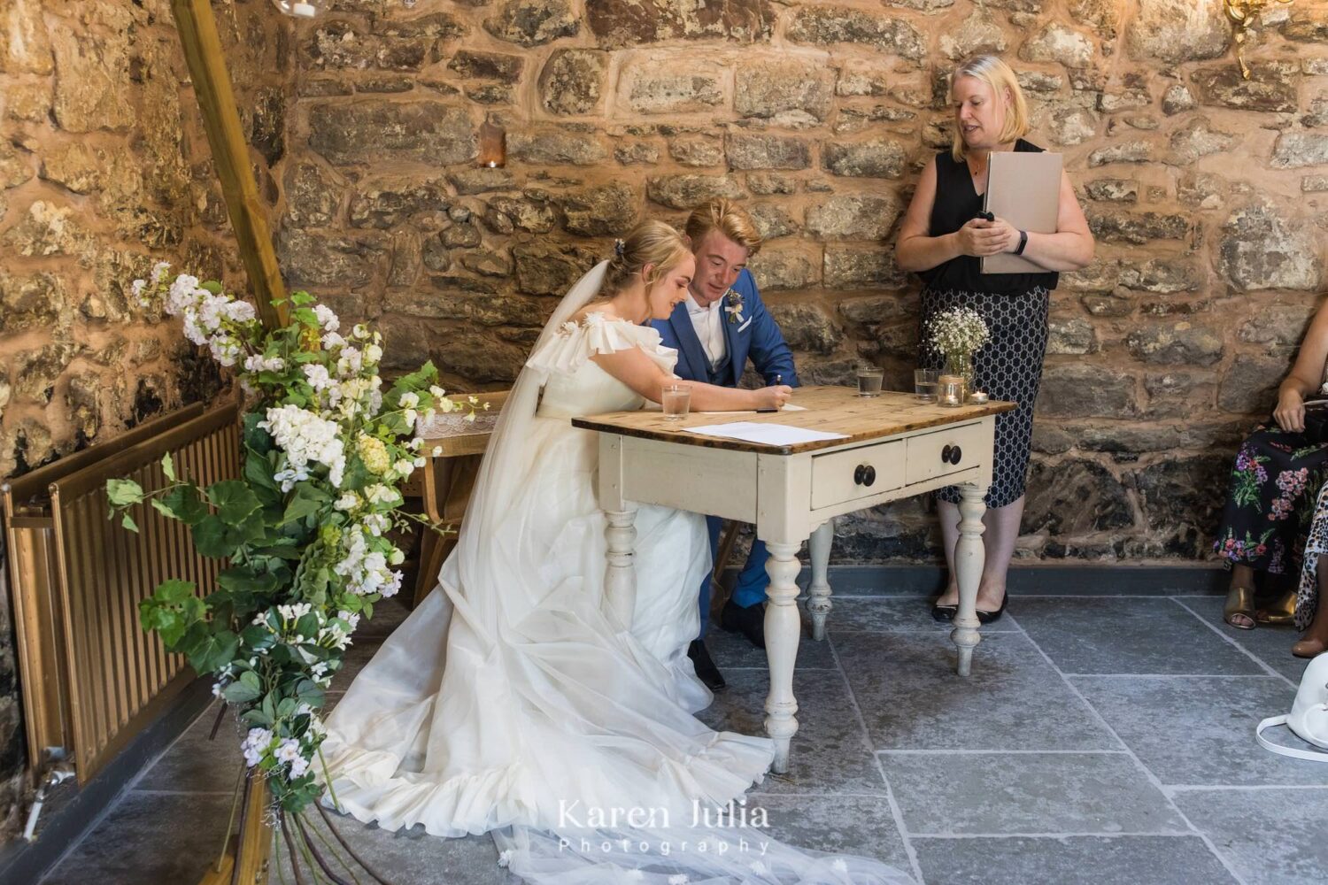the newly married couple sign the wedding register in the barn at Fruin Farm