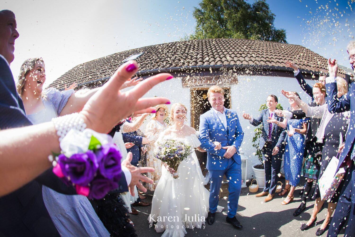bride and groom exit the barn and are showered with confetti