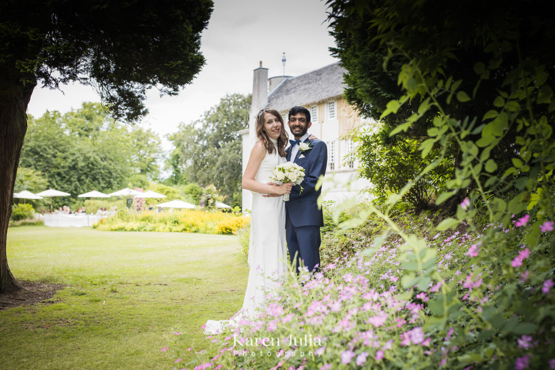bride and groom pose for a portrait in front of House for an art Lover