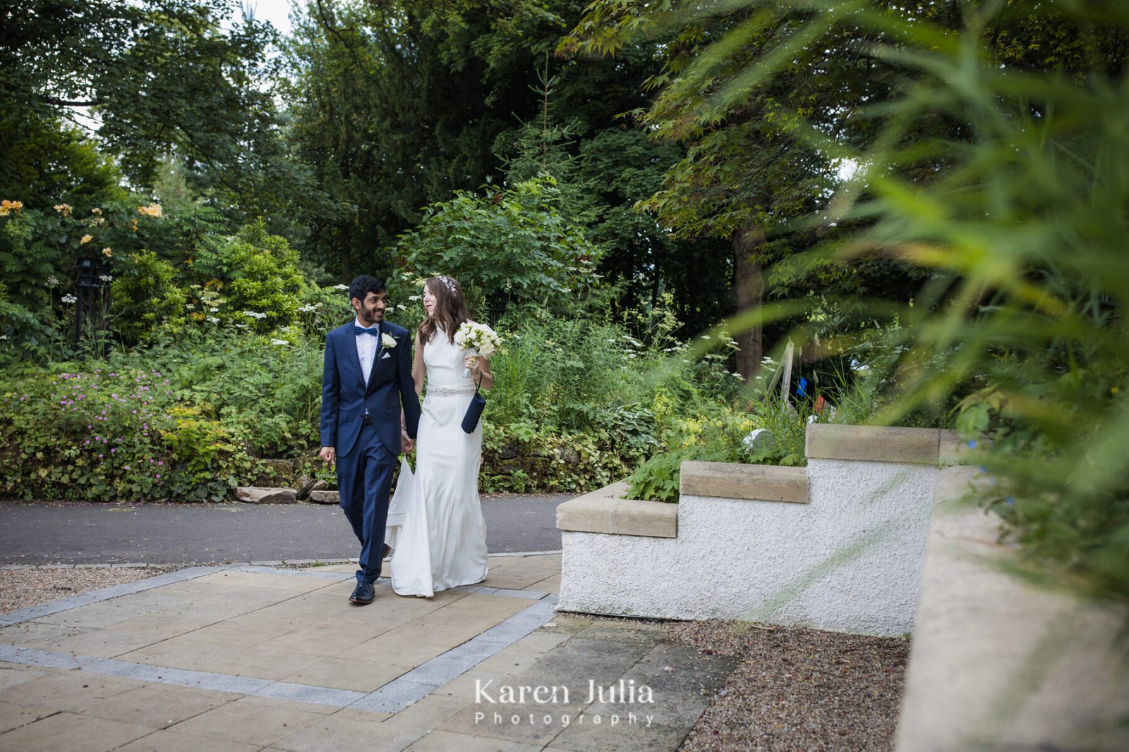 bride and groom walk hand in hand through the park outside House for an Art Lover