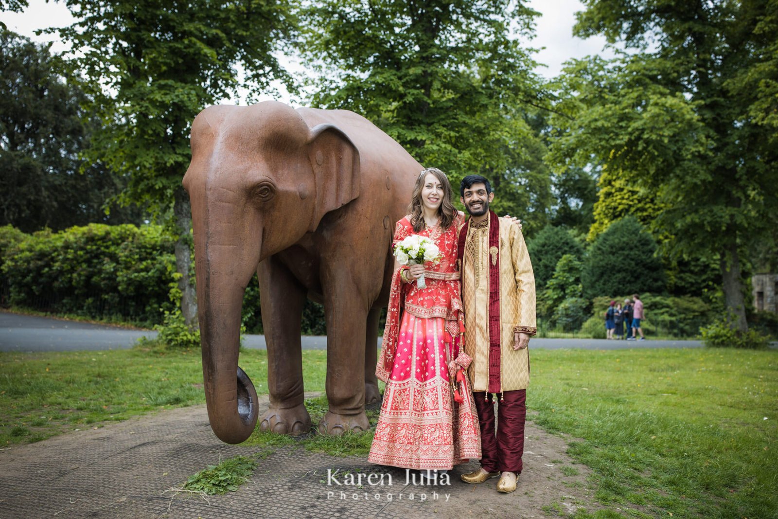 bride and groom pose for a wedding portrait next to the Elephant in Bellahouston Park