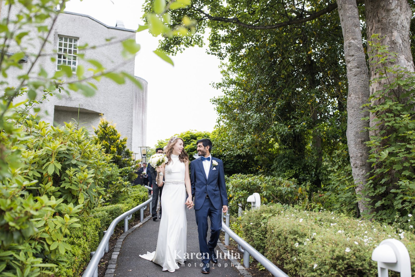 bride and groom walk out of House for an Art Lover and into Bellahouston Park