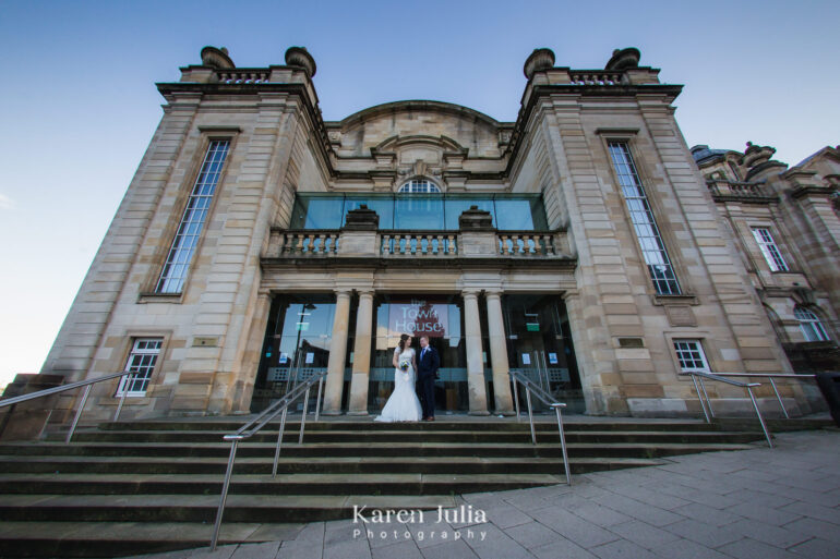 bride and groom portrait on their wedding day in front of The Town House, Hamilton