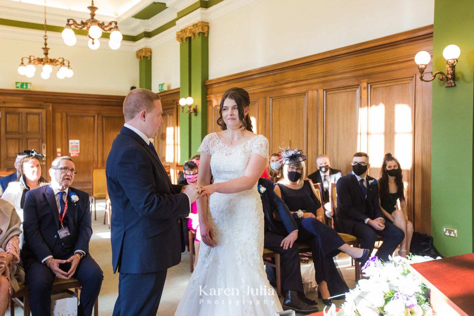 groom places a ring on the brides finger whilst saying his wedding vows