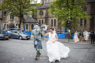 bride a groom cross road outside Òran Mór as they walk to Botanic Gardens