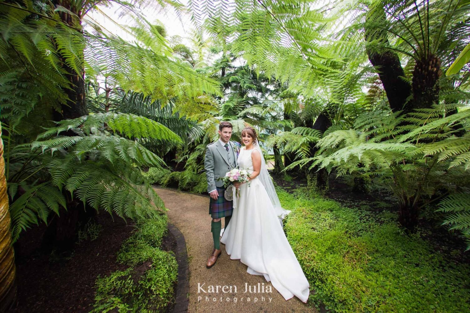 bride and groom have a portrait in Kibble Palace in Glasgow Botanic Gardens