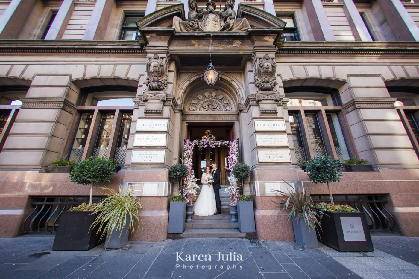 bride and groom have a couple portrait in the entrance of The Corinthian club on their wedding day