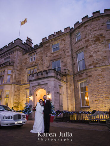 bride and groom outside Crossbasket Castle in winter