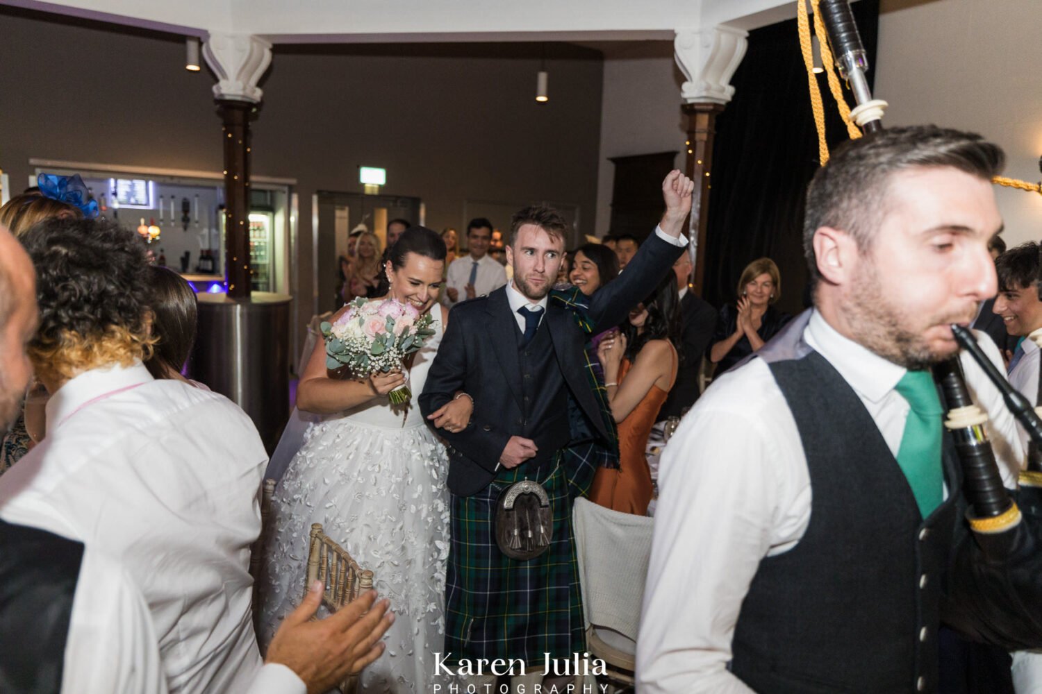 bride and groom enter the wedding breakfast in St Luke's as guests clap and cheer