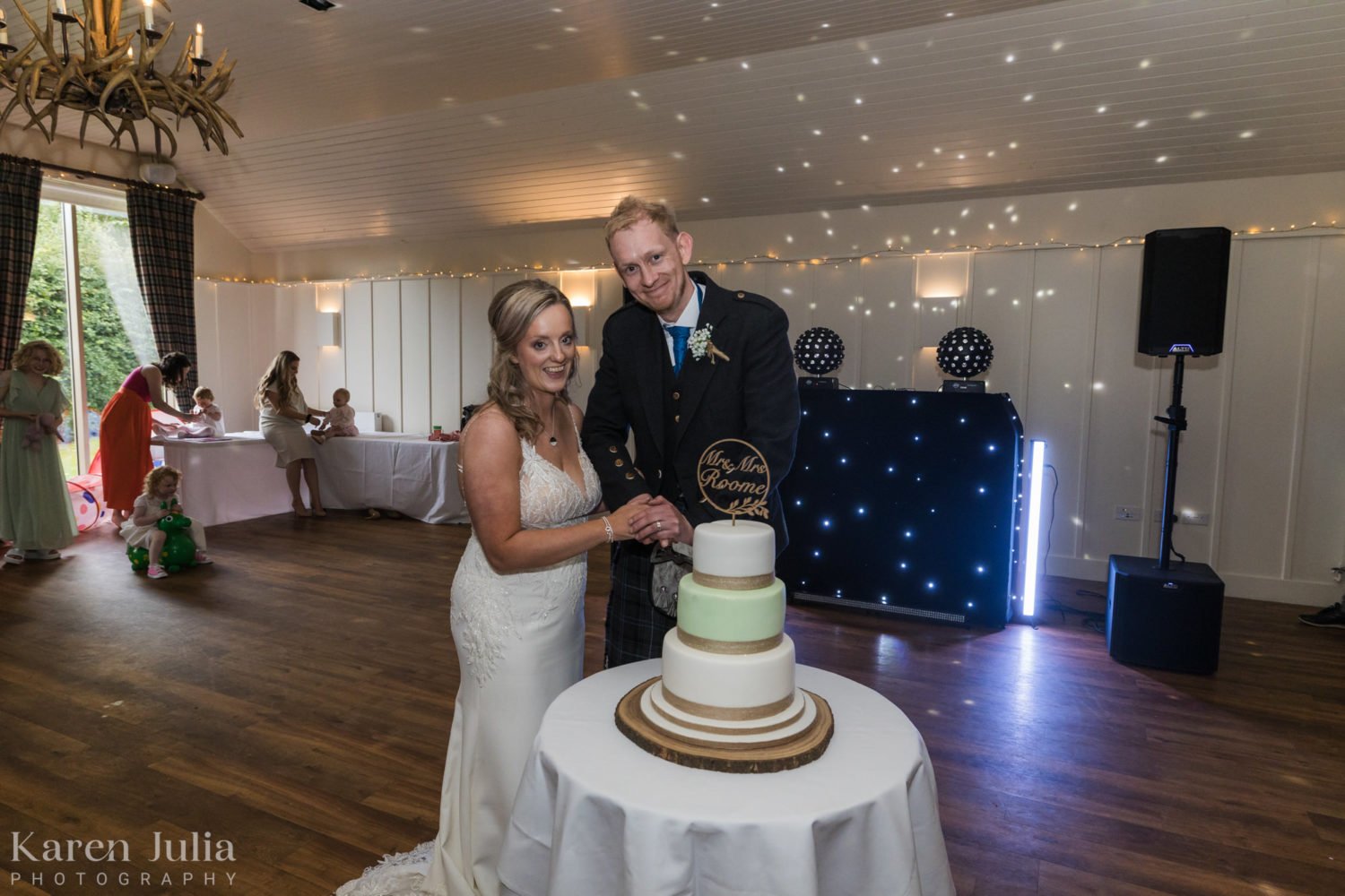 bride and groom cut the cake at their Loch Lomond Arms hotel wedding