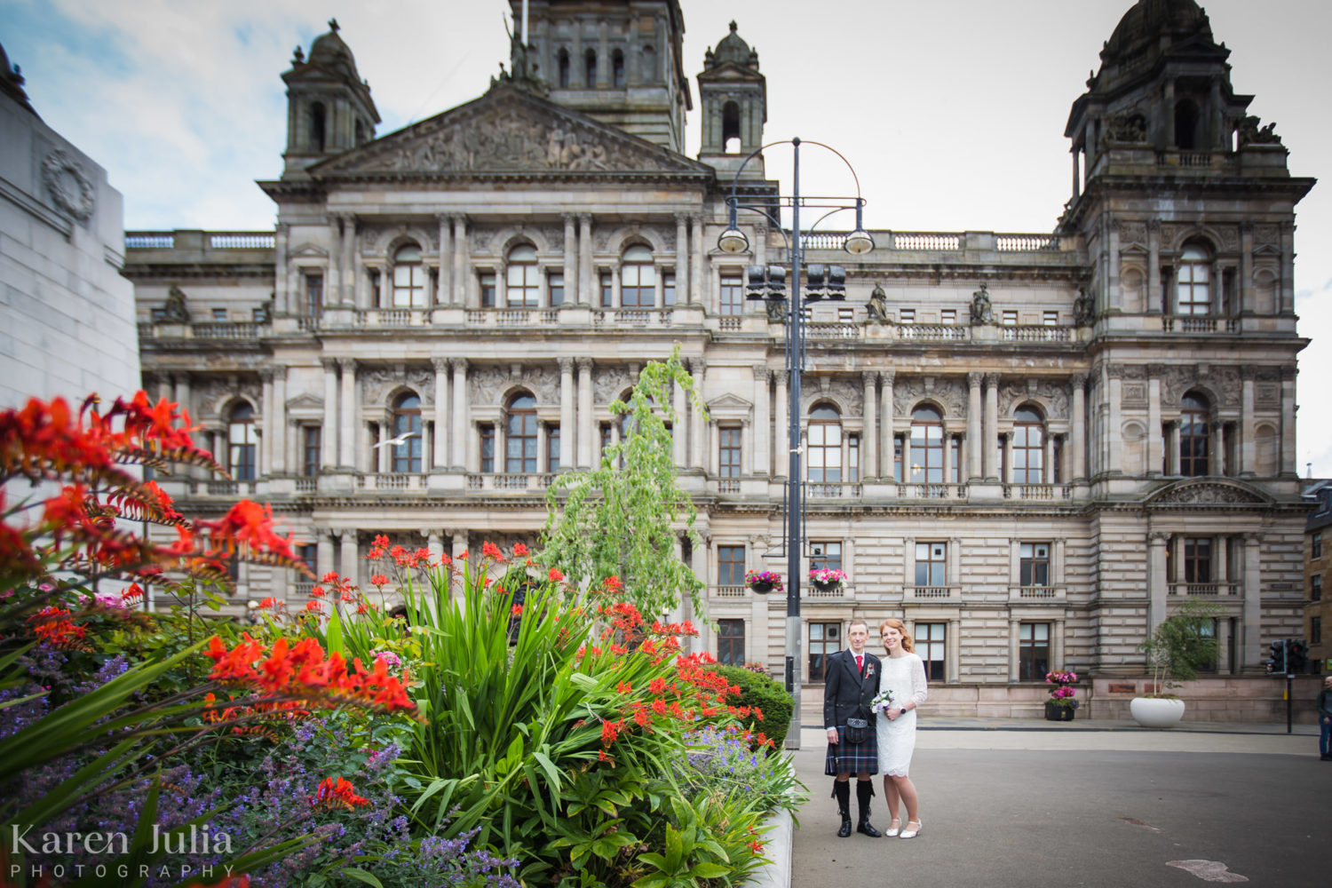 bride and groom portrait in George Square with vibrant colourful flowers