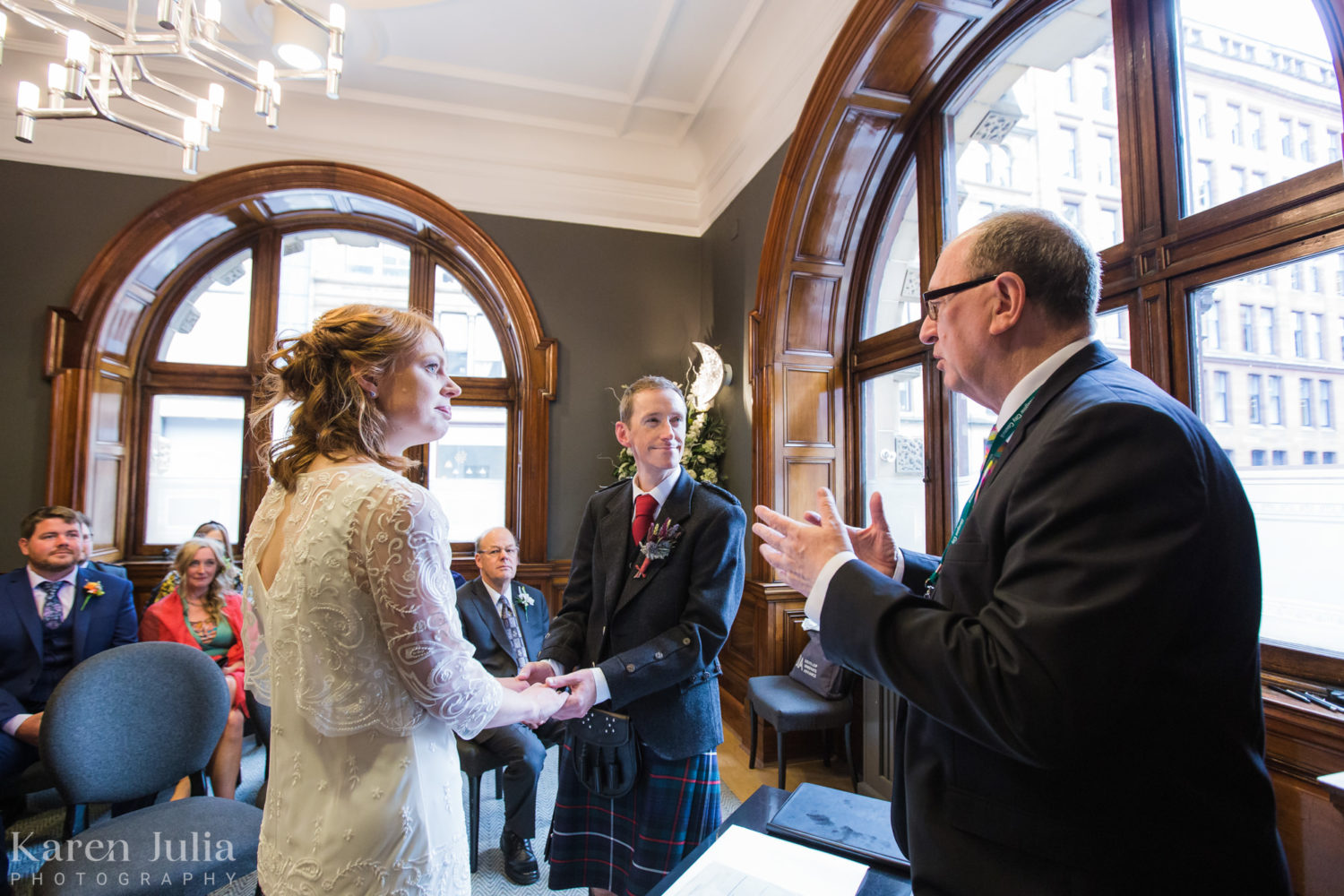 bride and groom exchanging vows during their wedding ceremony in the Clyde Room