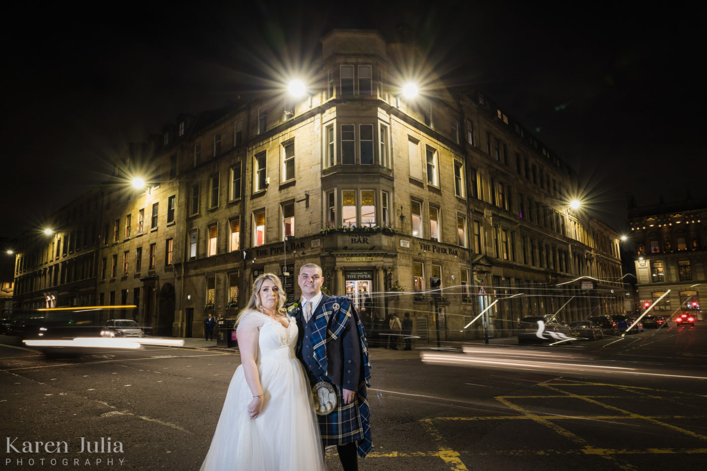 bride and groom night portrait with moving traffic outside Glasgow City Chambers