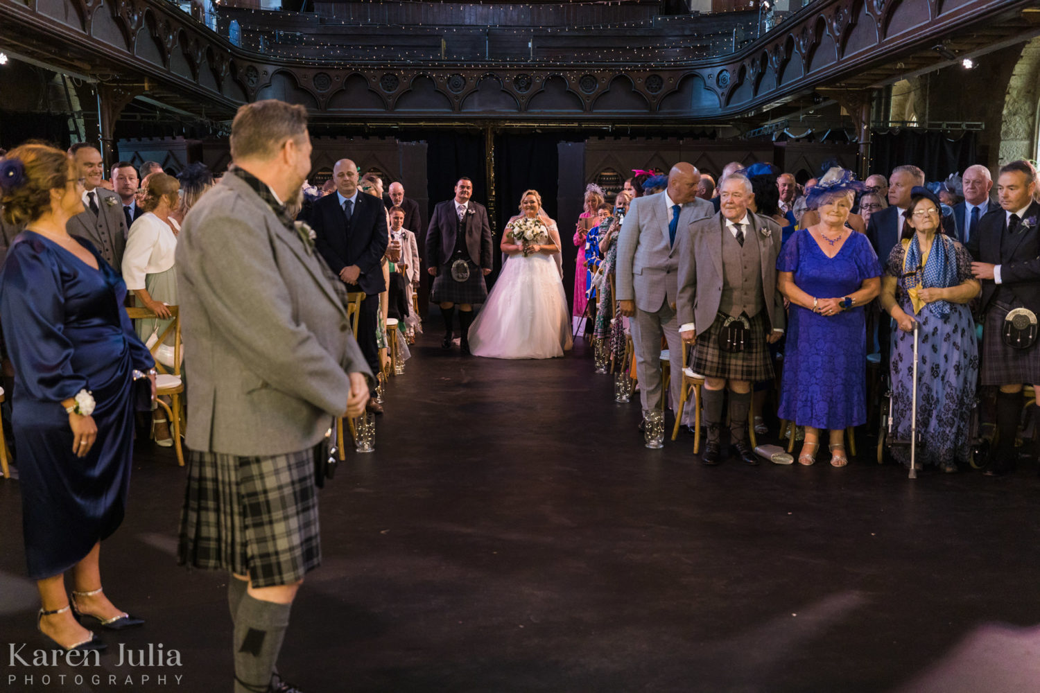 bride walks down the aisle in Cottiers to meet her groom