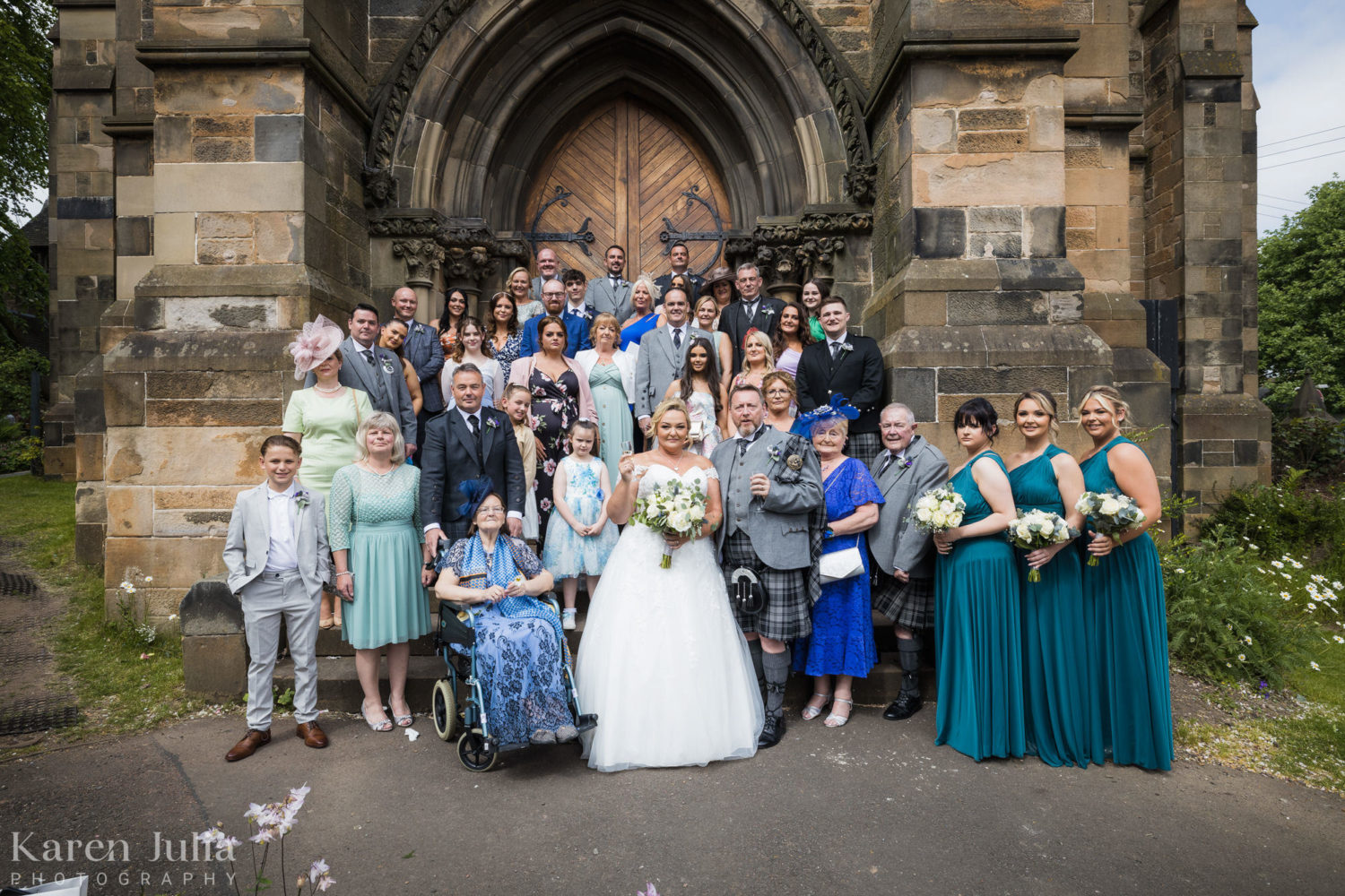 wedding party group photo at the front of Cottiers