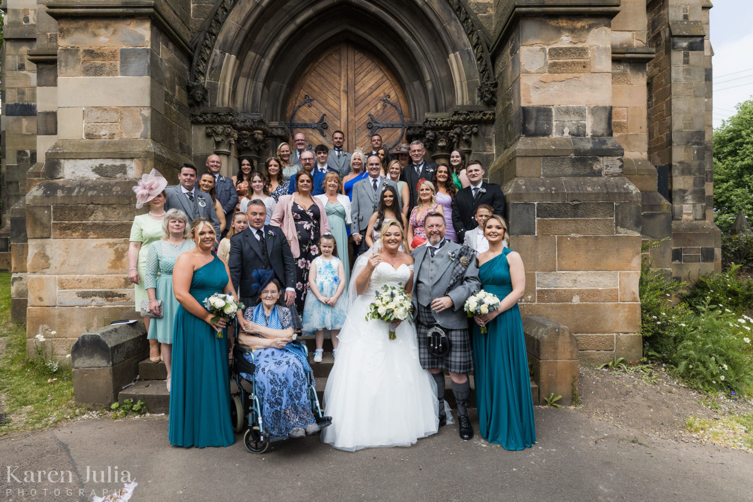 wedding party group photo at the front of Cottiers