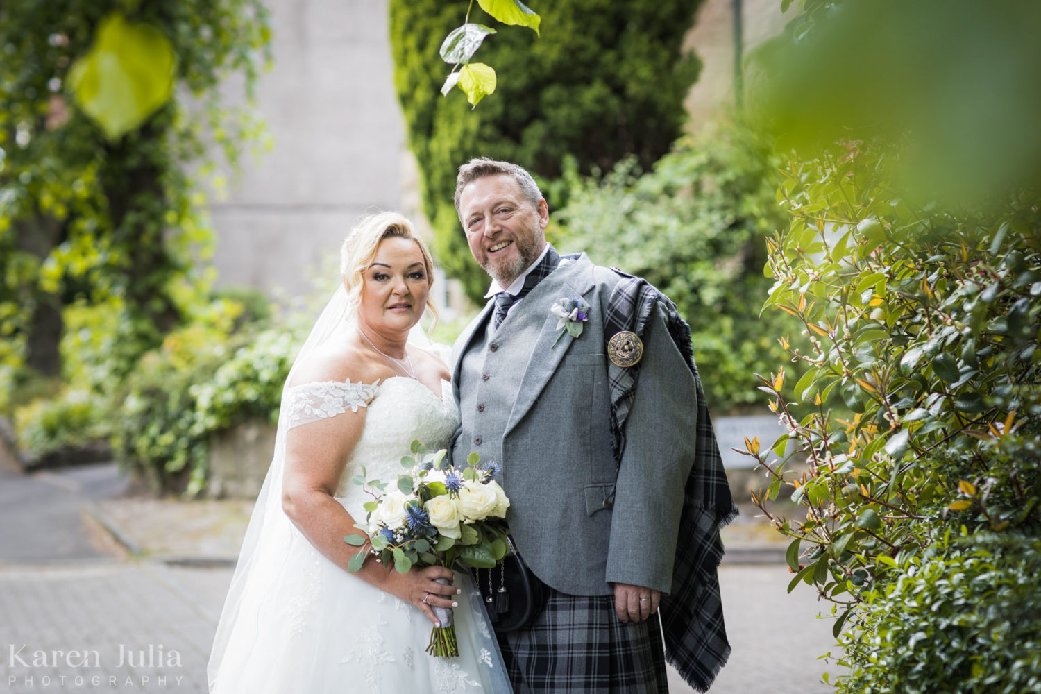 bride and groom portrait at the side of Cottiers on their wedding day