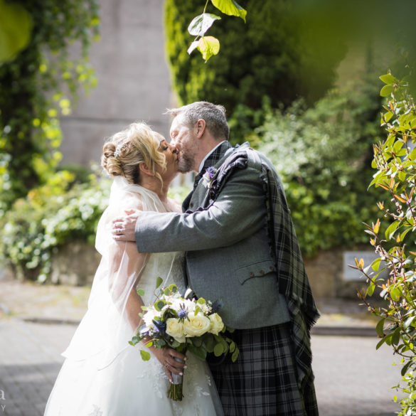 bride and groom share a kiss during their couple portraits at their Cottiers wedding