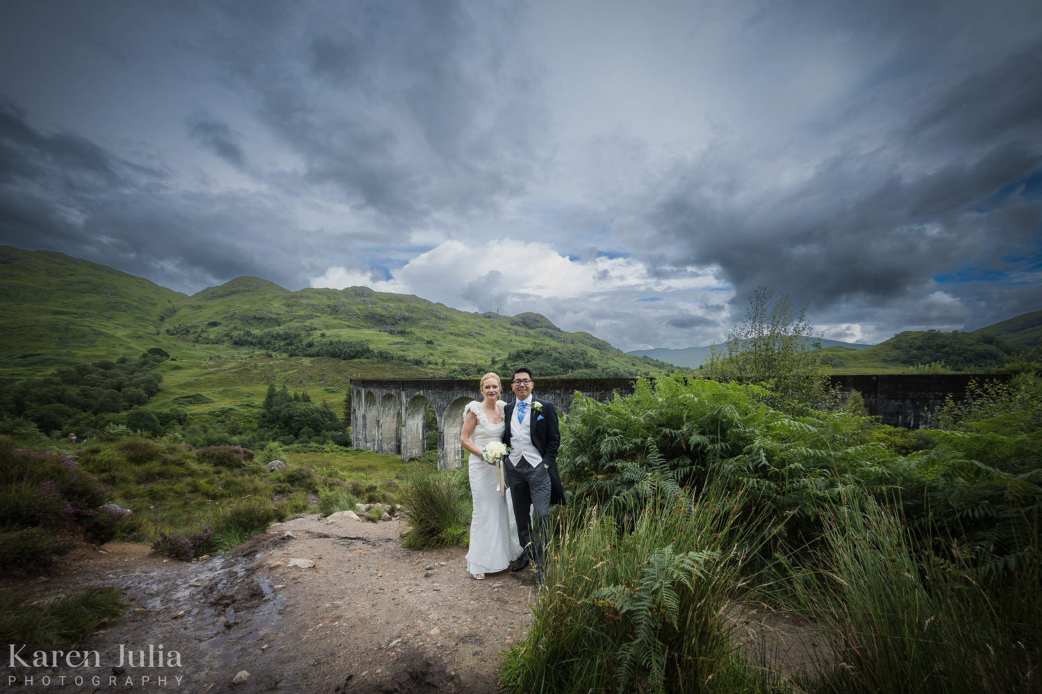 wide angle photo of bride and groom next to the Glenfinnan Viaduct