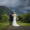 bride and groom standing facing the loch at Glenfinnan during their wedding portraits