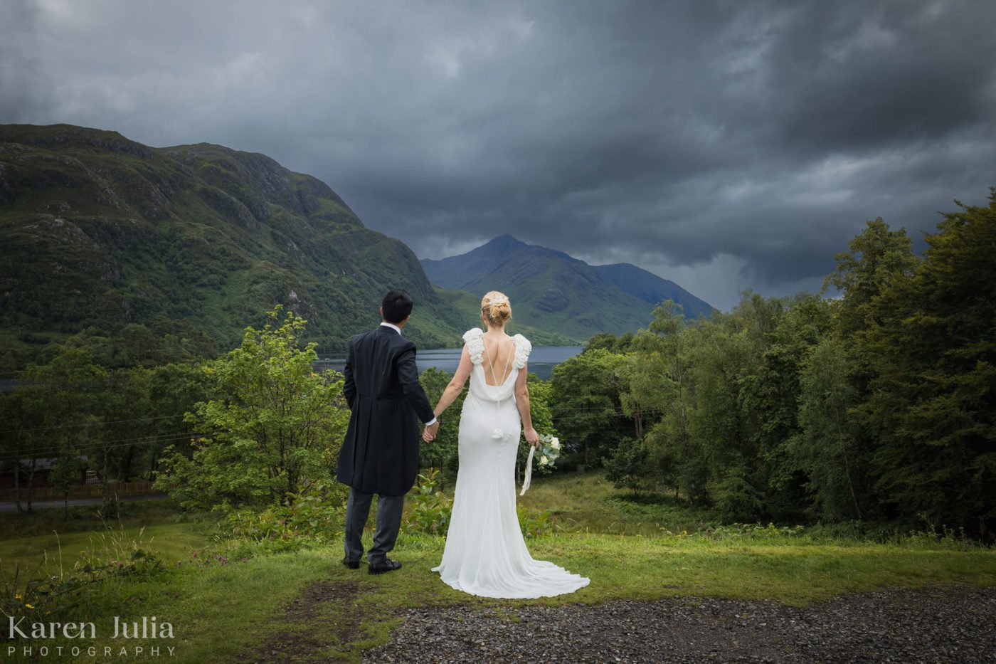 bride and groom hold hand in Glenfinnan on their elopement photography photoshoot