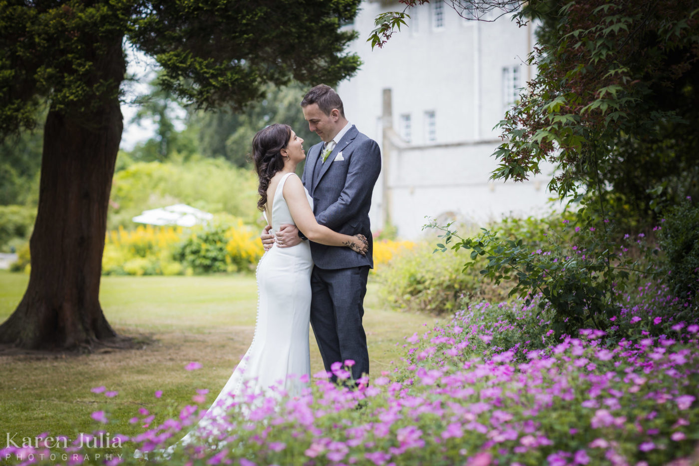 bride and groom embrace on their wedding day in the gardens at House for an Art Lover