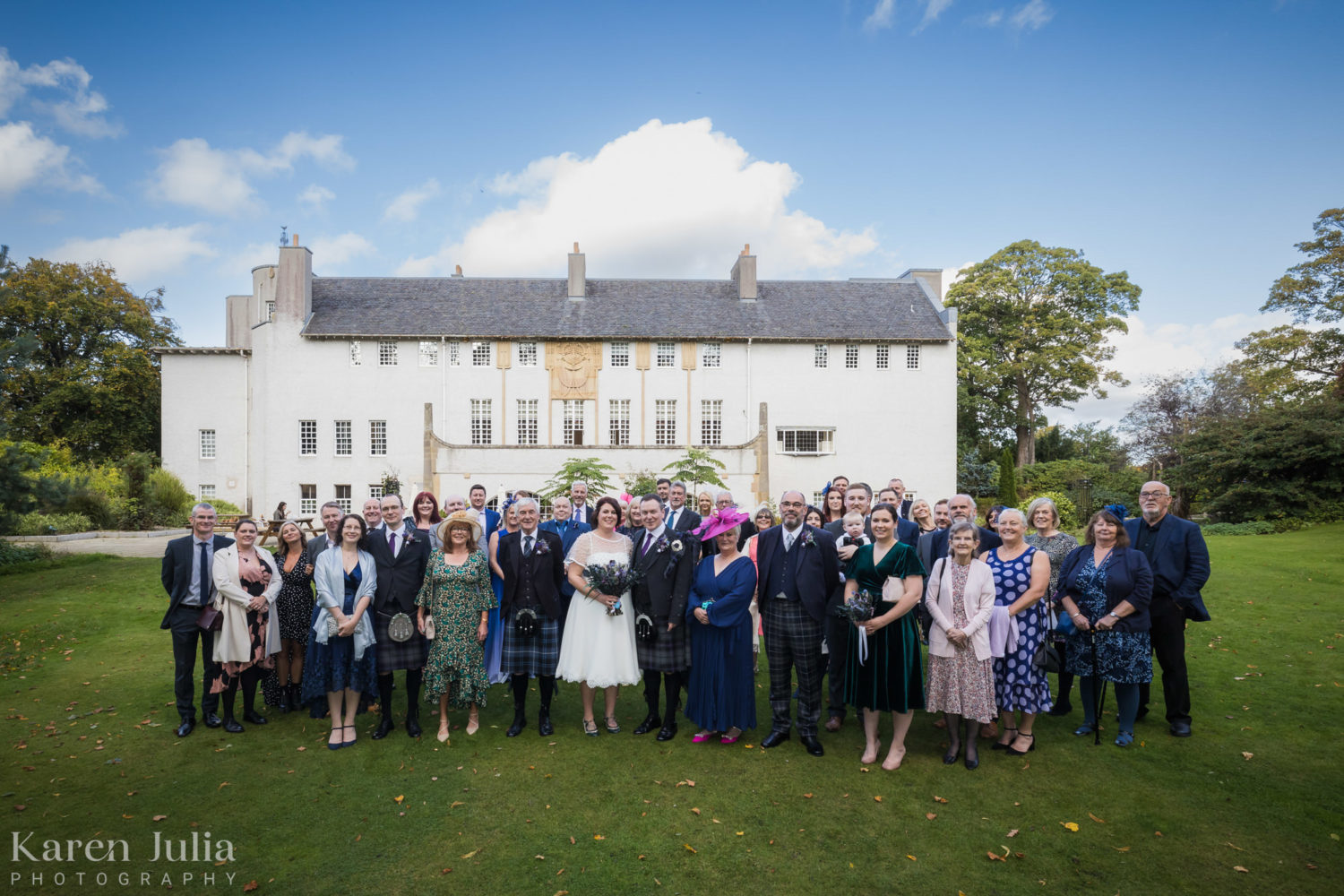 big group photo of all guests with House for an Art Lover in the background