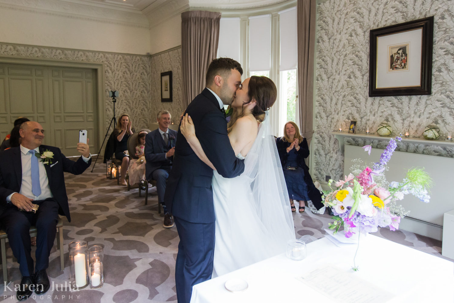 bride embraces groom with a kiss at the end of the wedding ceremony at One Devonshire Gardens