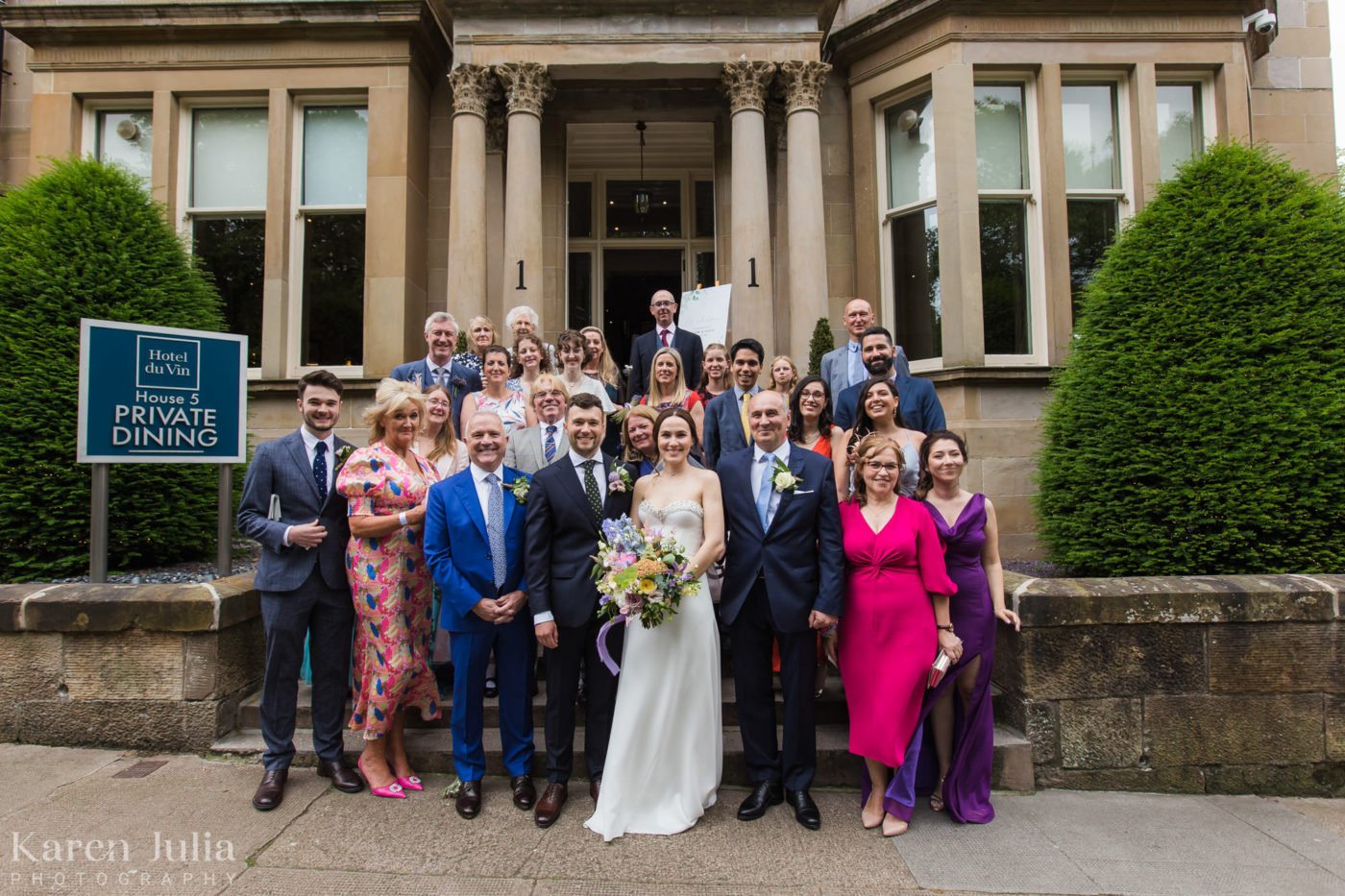 wedding group photo with all wedding guests on the stairs at One Devonshire Gardens