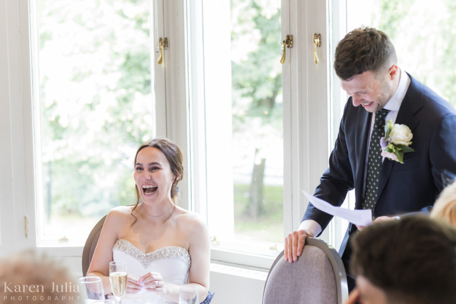 bride laughs as groom delivers speech 
