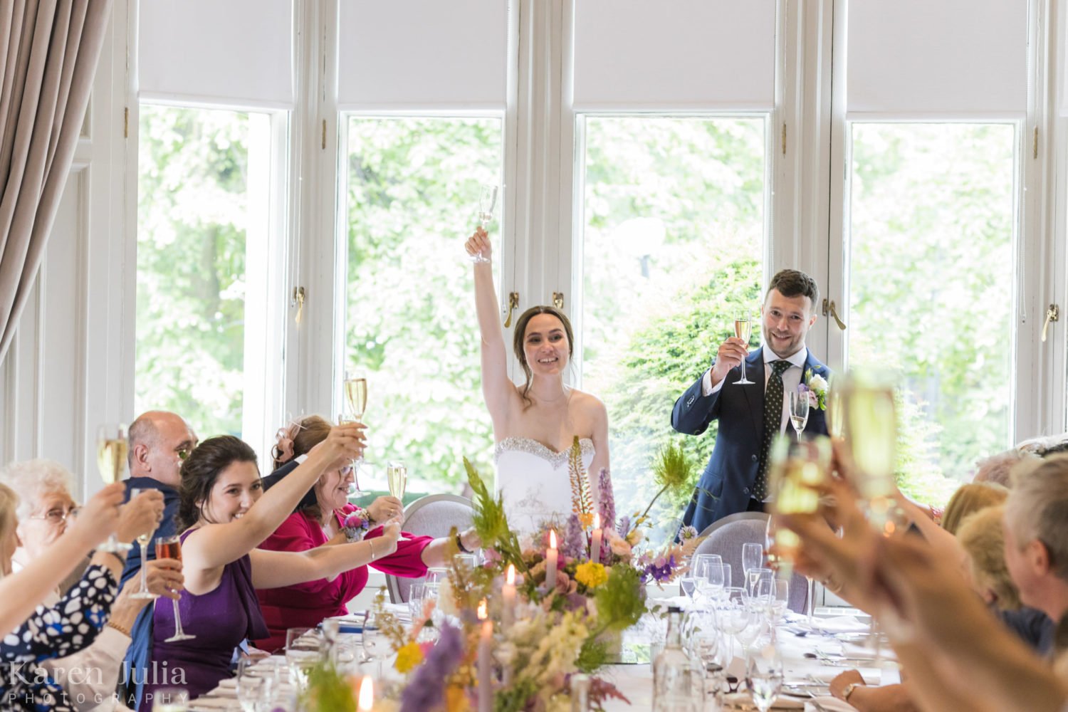 bride and groom raise glasses in a toast during speeches