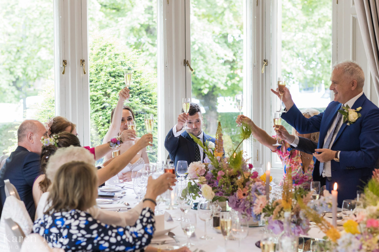 wedding guests raise their glasses in a toast to the couple