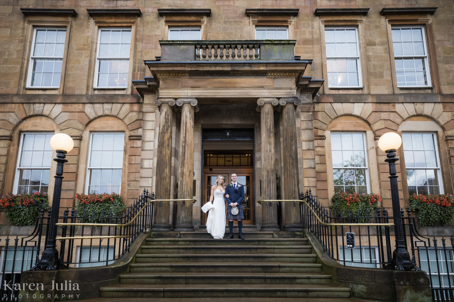 bride and groom pose for a wedding day portrait on the steps on Blythswood Square Hotel