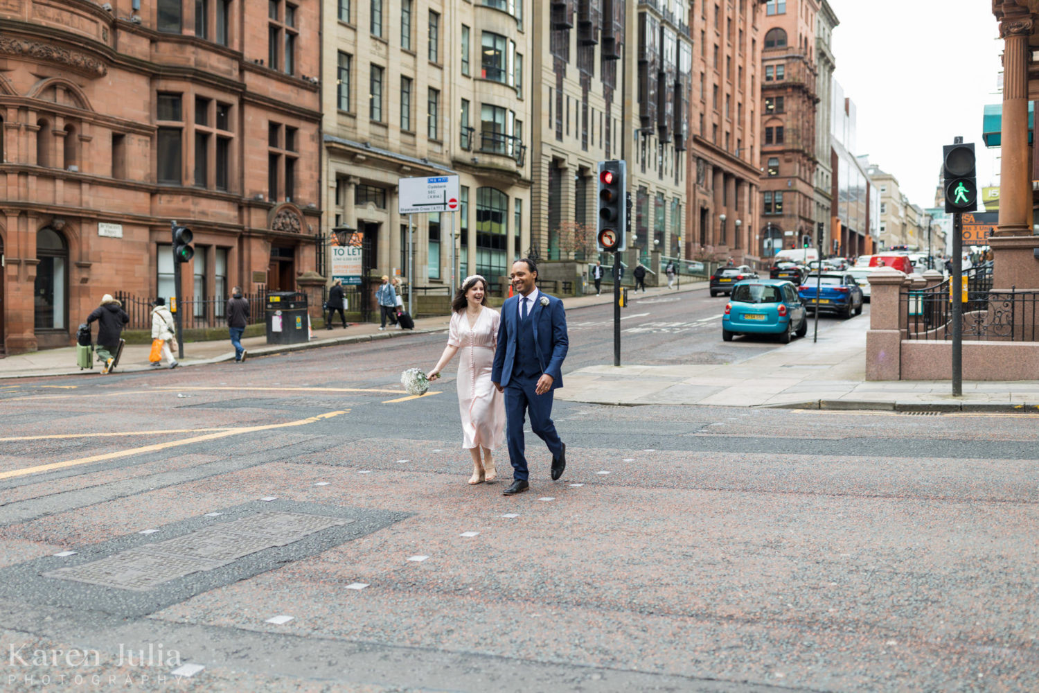 bride and groom walking through Glasgow City centre on their wedding day