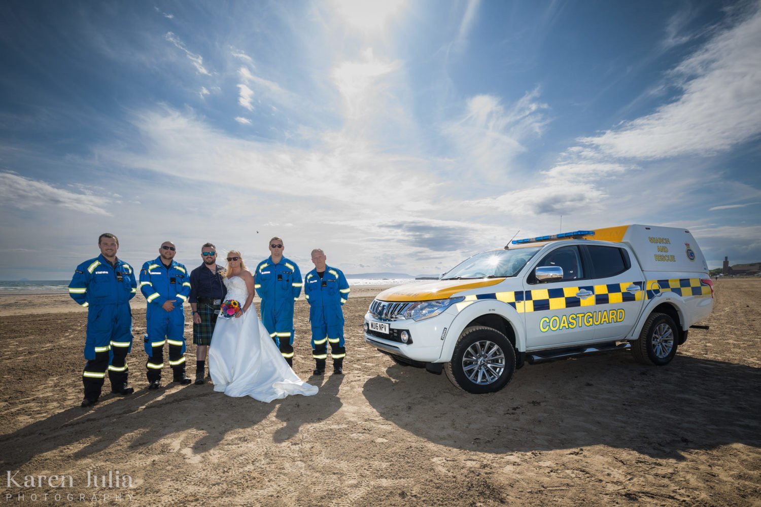 bride and groom pose with the coastguard