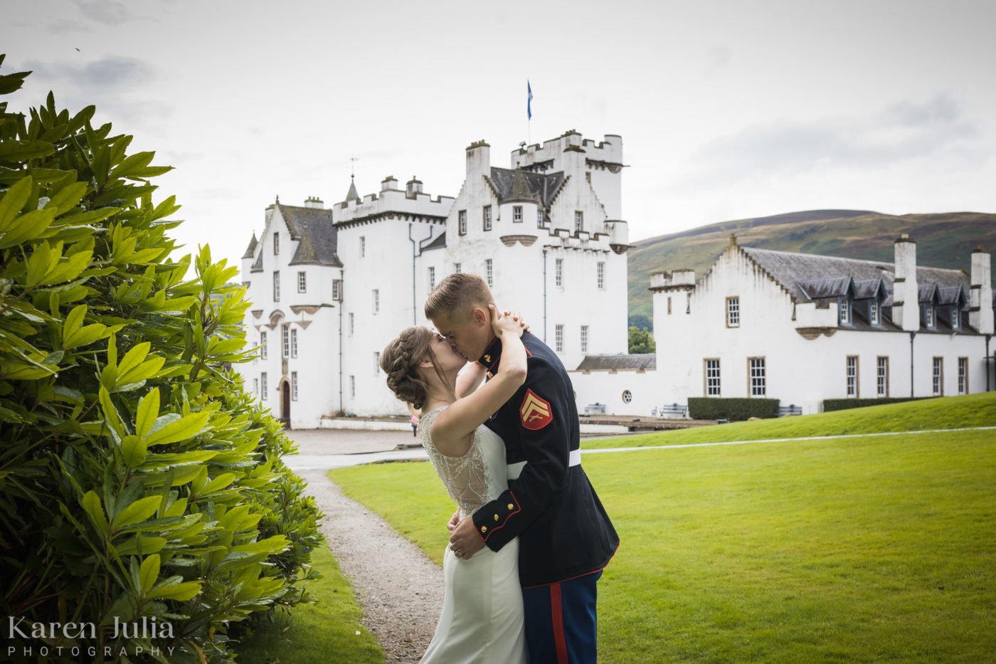 bride and groom exchange a kiss in front of a historic castle