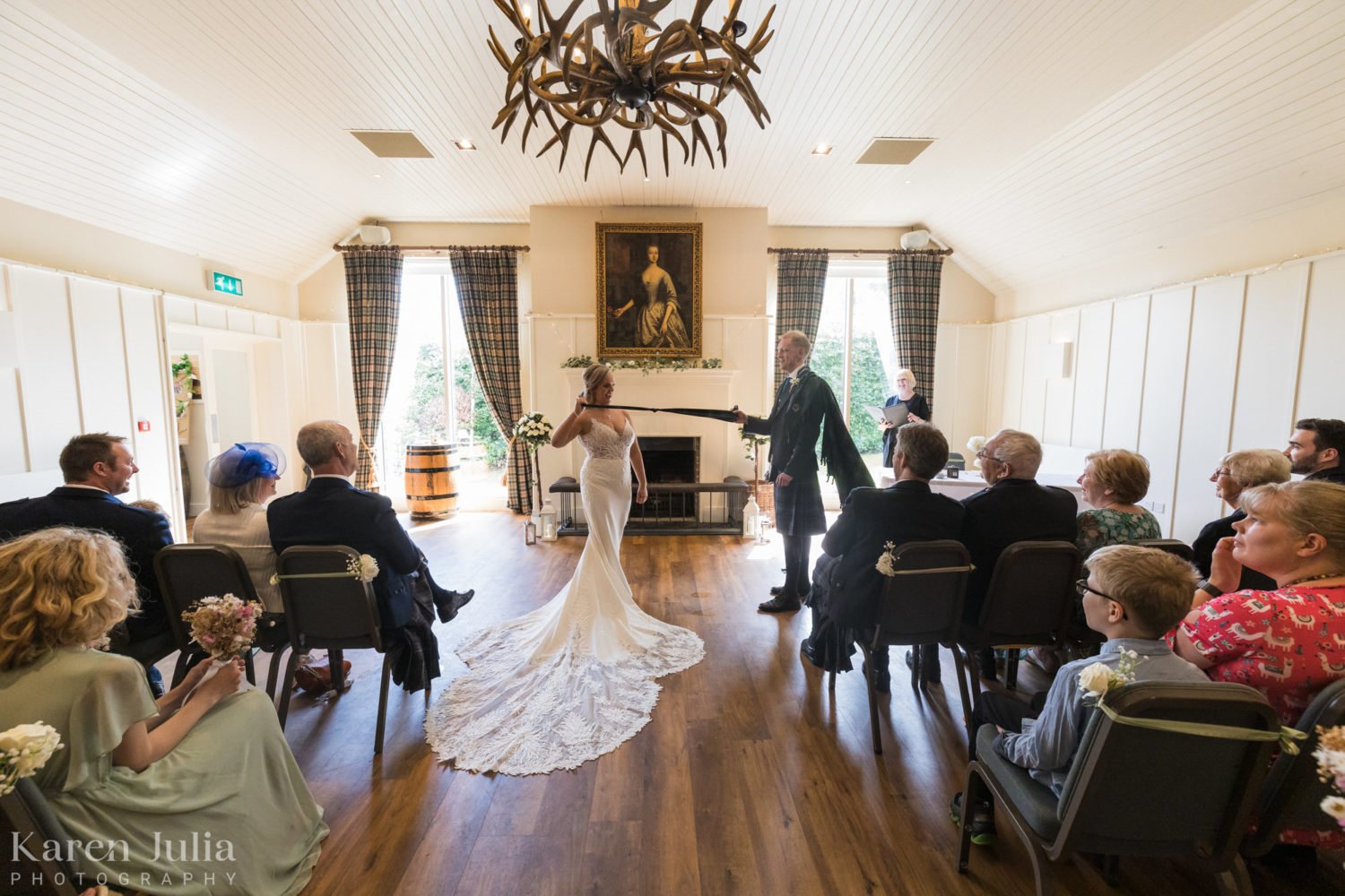bride and groom tie the knot during their wedding ceremony at Loch Lomond Arms hotel