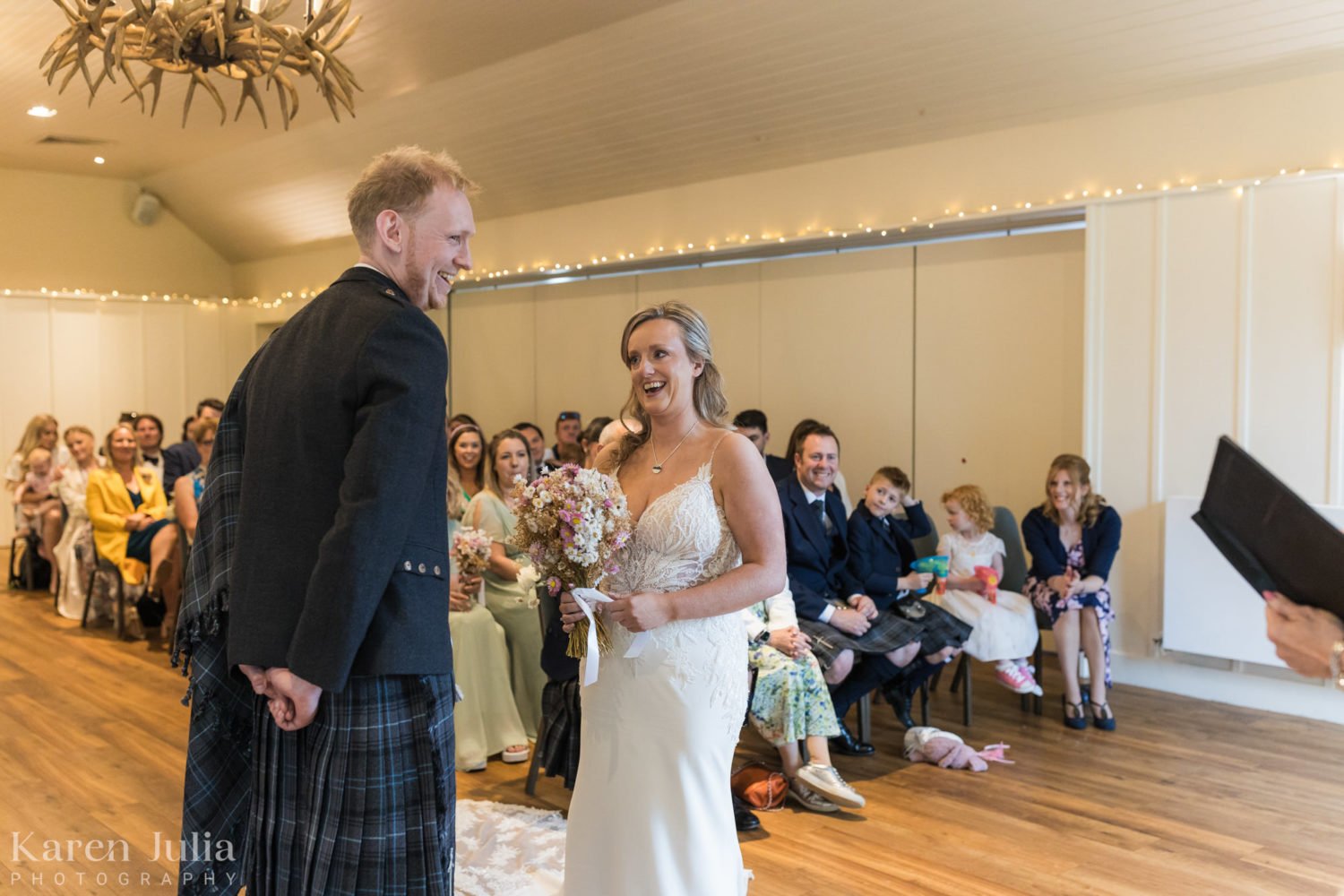 bride and groom exchanging vows during their wedding ceremony at Loch Lomond Arms hotel in Luss