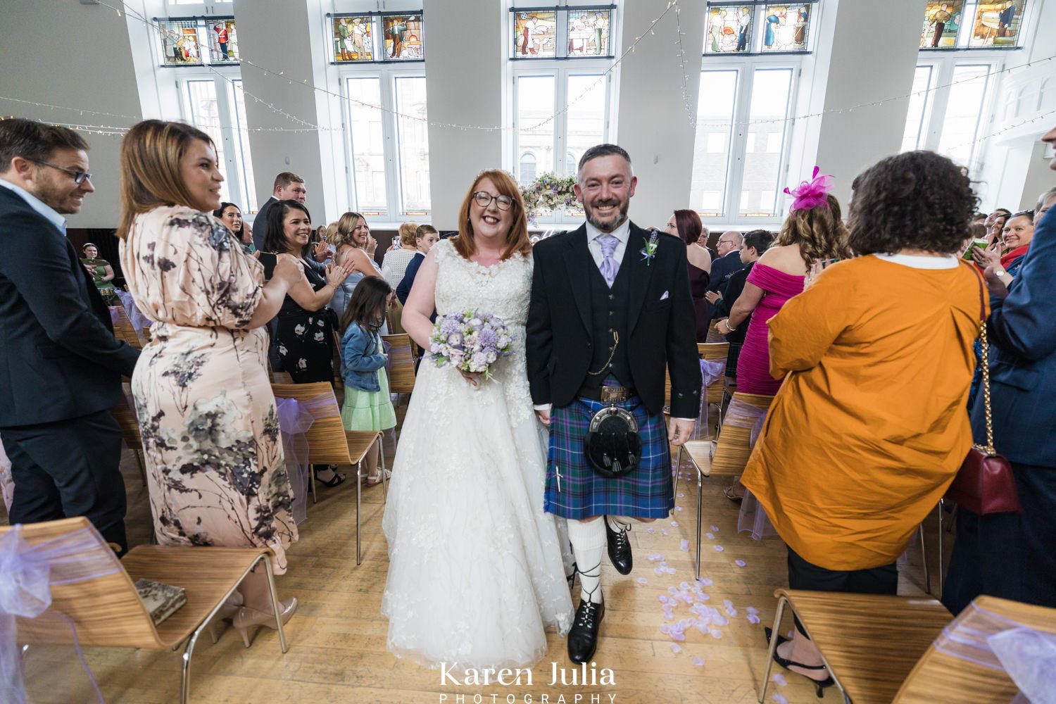 bride and groom walk up the aisle together as husband and wife