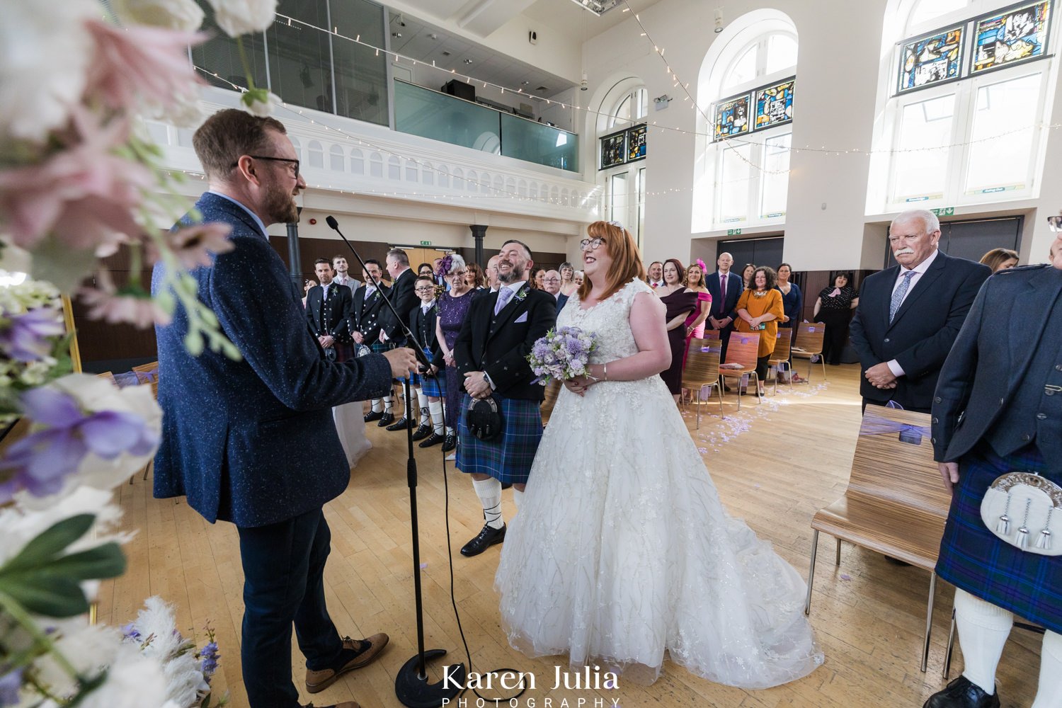 bride and groom stand together at their wedding ceremony at Maryhill Burgh Halls