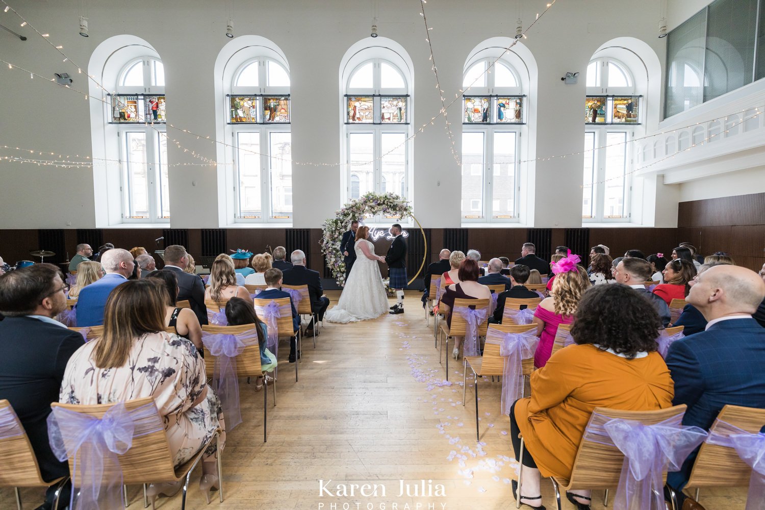 a wideangle view showing bride and groom and their wedding guests in the main hall