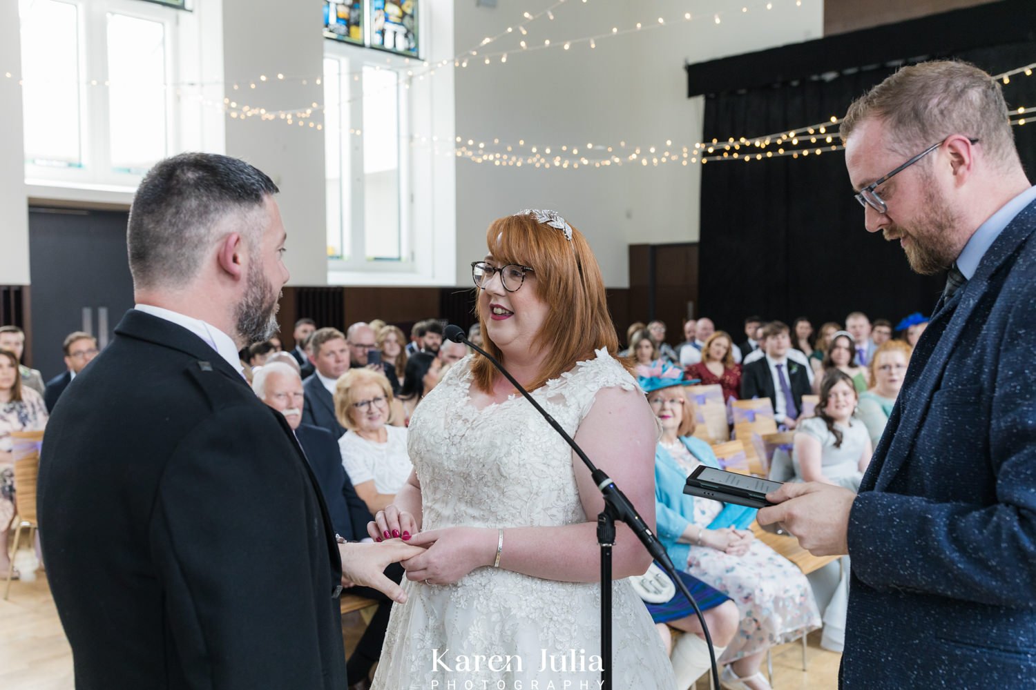 bride places ring on grooms finger during wedding ceremony