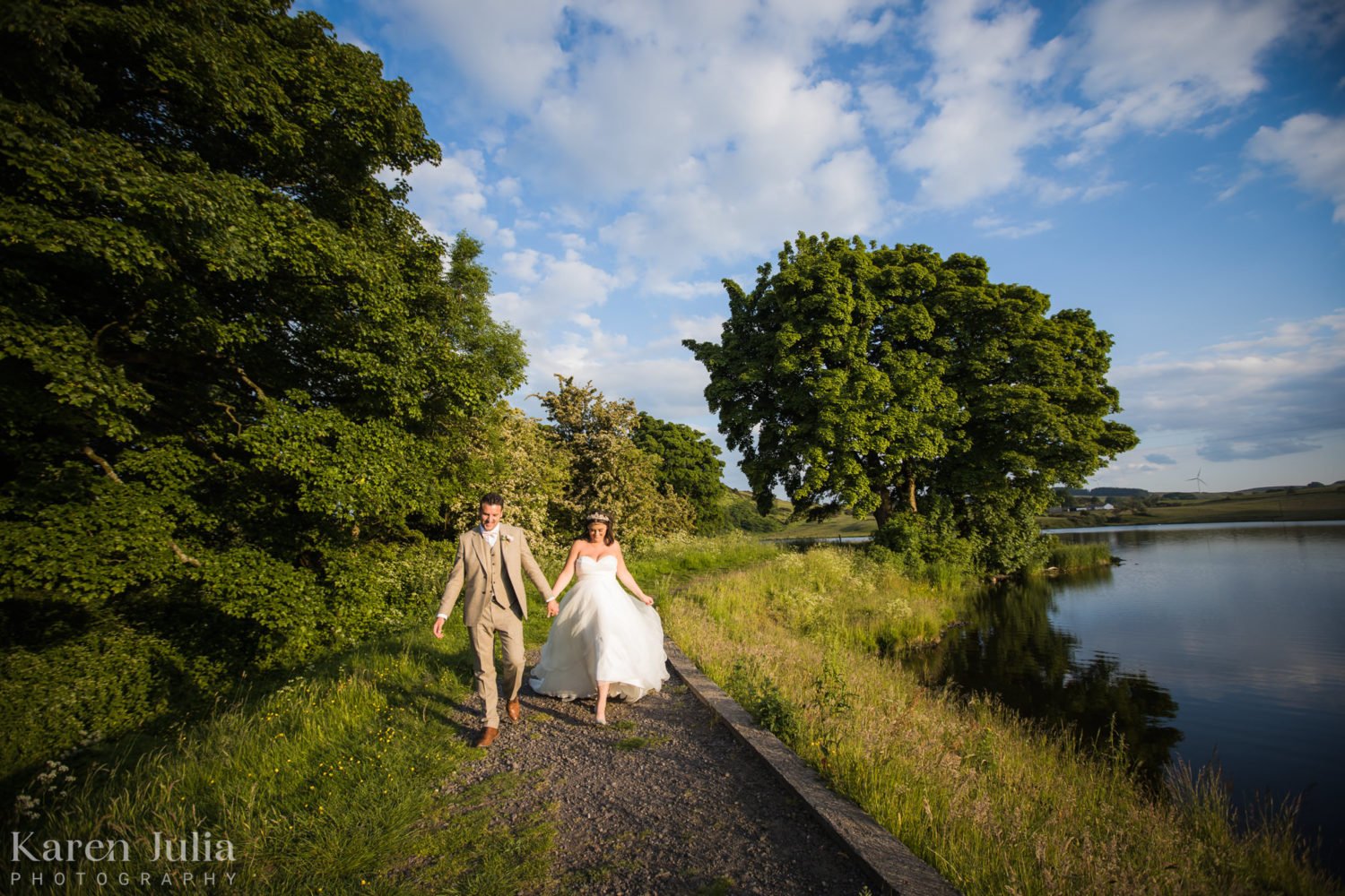 couple walking alongside Balgray reservoir during their summer solstice wedding