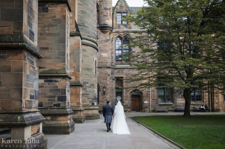bride and groom walking together at Glasgow University